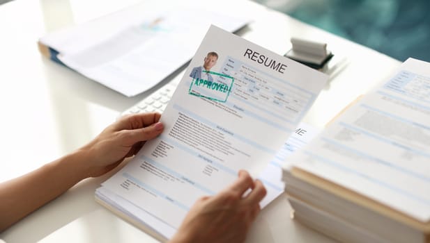 Hands holding resume of man for employment with stamp approved closeup. Work searches concept