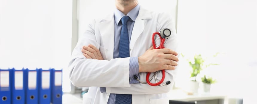 Male doctor in a white coat with a stethoscope in his hands, close-up. Consultation with a cardiologist, pulmonologist diagnosis