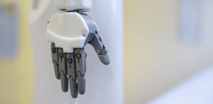 Robot hand on a gray background, close-up. Industrial robotics. Mechanical assistant. Bionic manipulator