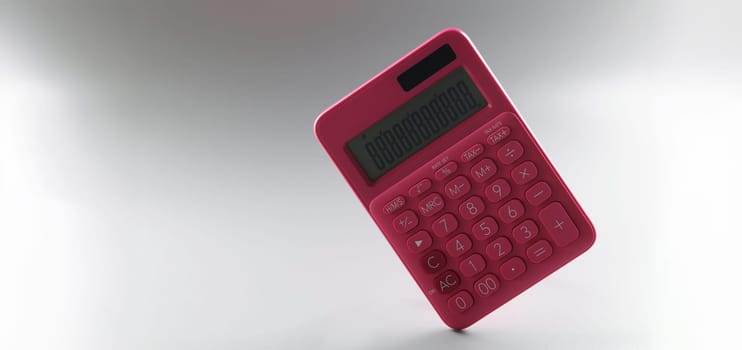 Red calculator on a gray background, close-up. The concept of cash accounting, costing, goods inventory