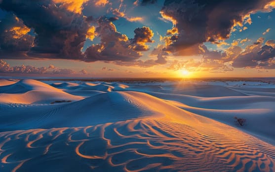 Clouds adorned with sunset colors hover above undulating sand dunes. The last rays of sunlight paint a masterpiece in the sky