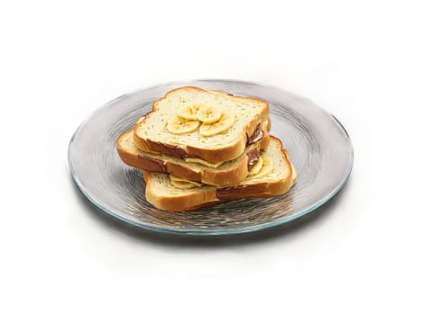 Toast challah with a thin layer of Nutella and banana slices on a transparent glass. Food isolated on transparent background.
