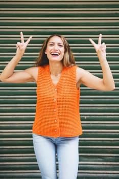 Vertical urban portrait of a successful beauty latin woman gesturing standing outdoors