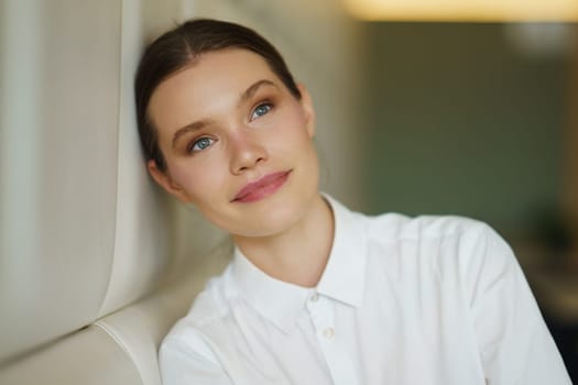 Pensive beauty young businesswoman dreaming about the future sitting on a comfortable cafeteria