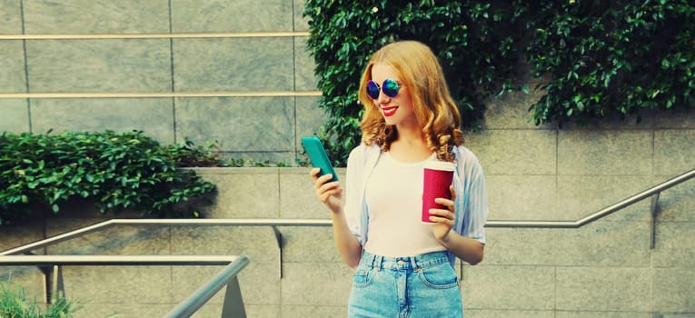 Beautiful young woman with smartphone and coffee cup in the city