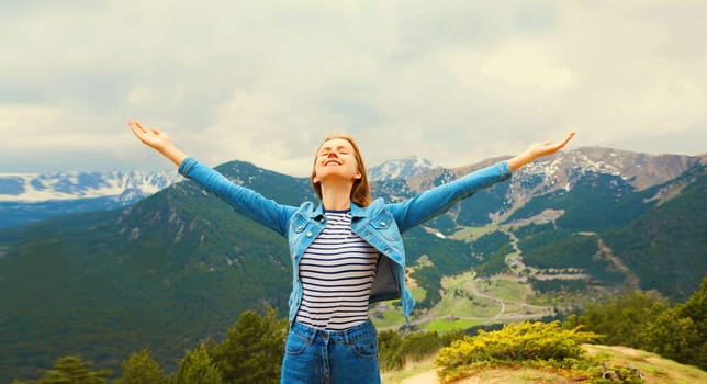 Travel, adventure, happy woman tourist enjoying fresh air mountains raising her hands up on Andorra
