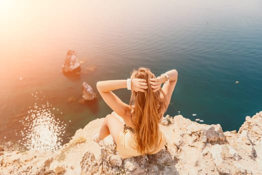 Woman travel sea. Happy tourist taking picture outdoors for memories. Woman traveler looks at the edge of the cliff on the sea bay of mountains, sharing travel adventure journey.