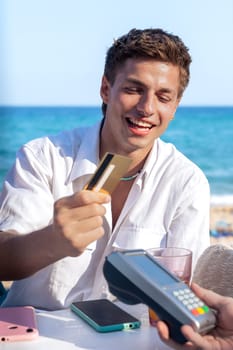 Young man holding a credit card and making a payment transaction.