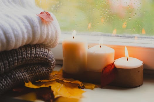 A burning candle on the window is autumn . the comfort of home . autumn comfort . autumn mood. The chondra .