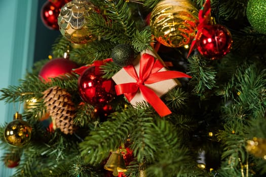 Close-up cropped shot of beautiful Christmas tree decorated with festive balls and celebration warm lights at home, selective focus.