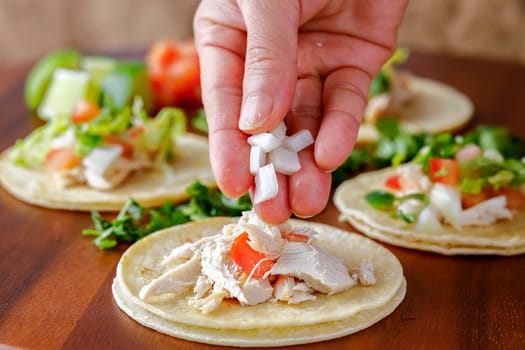 A close up studio photo of putting chopped onions on a street taco.