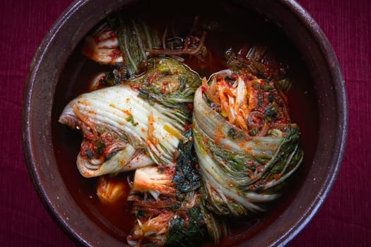 A studio overview of whole kimchi freshly made inside a large pot. A staple side dish in Korea.