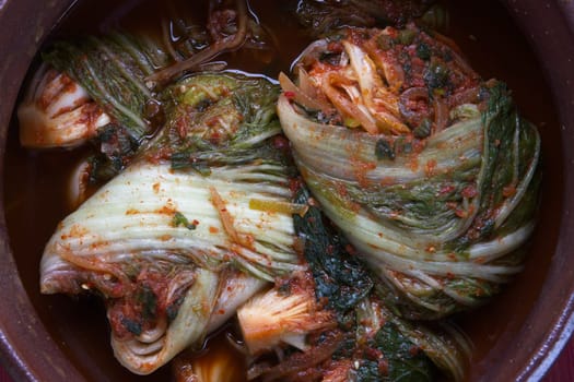 A studio overview of whole kimchi freshly made inside a large pot. A staple side dish in Korea.