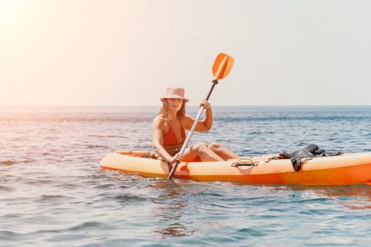 Happy smiling woman in kayak on ocean, paddling with wooden oar. Calm sea water and horizon in background