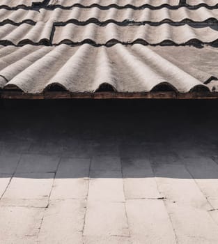 A roof with a tile pattern and a shadow on the ground