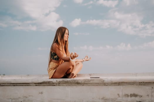 Woman park yoga. Side view of free calm bliss satisfied woman with long hair standing in morning park with yoga position against of sky by the sea. Healthy lifestyle outdoors in park, fitness concept