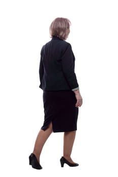 in full growth. Mature business woman walking away. isolated on a white background