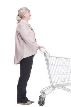 side view. elderly lady with a shopping cart looking at you with a smile. isolated on a white background.