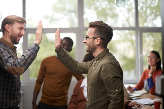 Group of businessman and businesswoman celebrating victory and teamspirit giving high five in air closeup