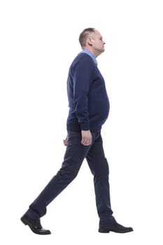 mature man in blue jumper striding forward. isolated on a white background.