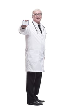 in full growth.qualified mature doctor showing his visiting card . isolated on a white background.