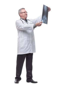 Attractive doctor wearing glasses and with stethoscope examining an x-ray and smiling at the camera