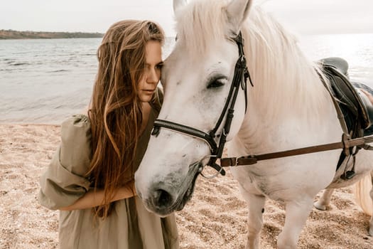 A white horse and a woman in a dress stand on a beach, with the sky and sea creating a picturesque backdrop for the scene