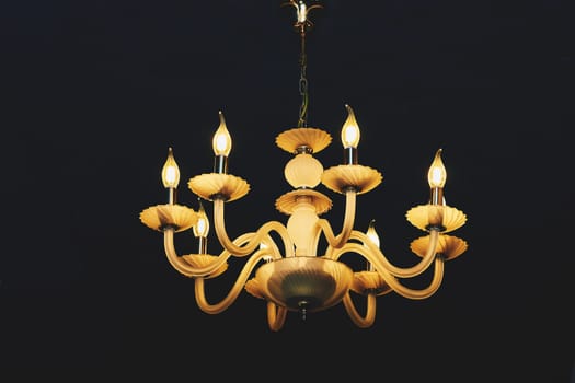 a decorative hanging light with branches for several light bulbs or candles