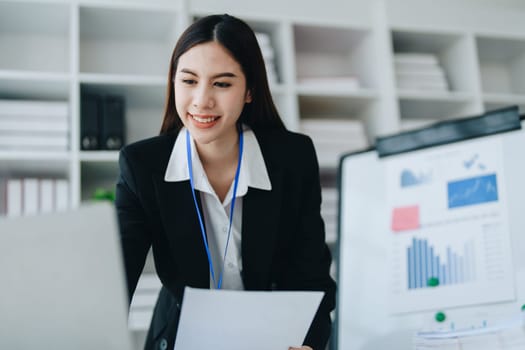 Portrait of young asian woman holding notebook with presentation of strategy, investment plan and marketing