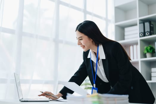 Portrait of young asian woman holding notebook with presentation of strategy, investment plan and marketing