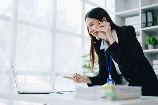 Portrait of young asian woman holding notebook with presentation of strategy, investment plan and marketing