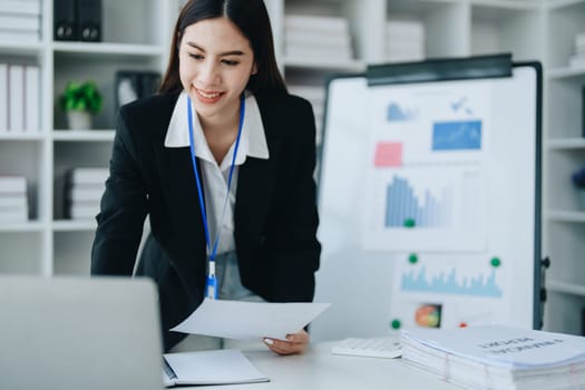 Portrait of young asian woman holding notebook with presentation of strategy, investment plan and marketing