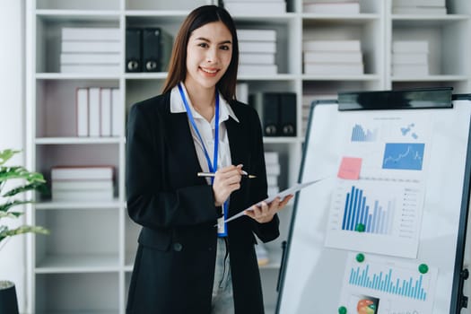 Portrait of young asian woman holding notebook with presentation of strategy, investment plan and marketing