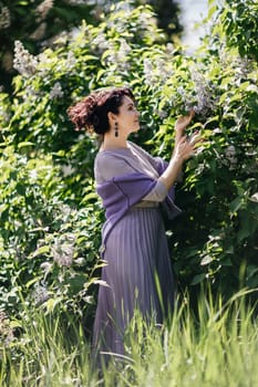 Woman lilac. Portrait of an happy woman surrounded by lilac bushes. Spring seasonal photos