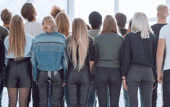 rear view. a large group of young people looking at a large white screen. photo with copy space