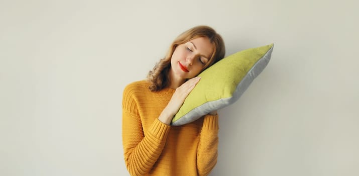 Healthy sleep, happy relaxed sleepy young woman hugs her soft comfortable pillow imagining that she is lying on the bed