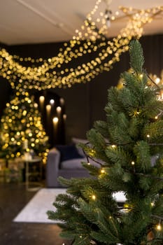 Christmas interior with a beautiful Christmas tree, sofa, light bulbs and dark background