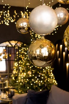 Christmas interior with a beautiful Christmas tree, sofa, light bulbs and dark background