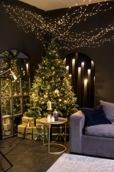 Christmas interior with a beautiful Christmas tree, sofa, light bulbs and dark background