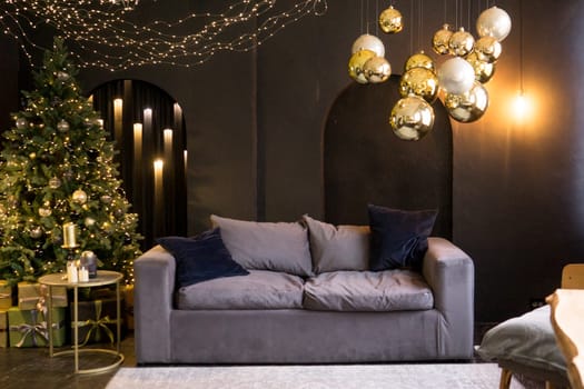 Christmas interior with a beautiful Christmas tree, sofa, light bulbs and dark background