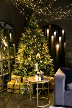 Christmas interior with a beautiful Christmas tree, sofa, light bulbs and dark background