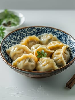Asian dumplings in a traditional bowl with herbs on a plate, a delicious appetizer and meal