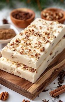 Delicious white chocolate nougat with pecans on a wooden board, a sweet dessert for holidays