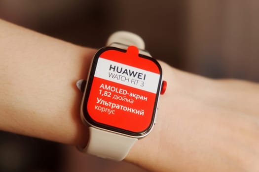Tyumen, Russia-June 20, 2024: Huawei Watch Fit 3 on a persons wrist. The watch face is displaying a red screen