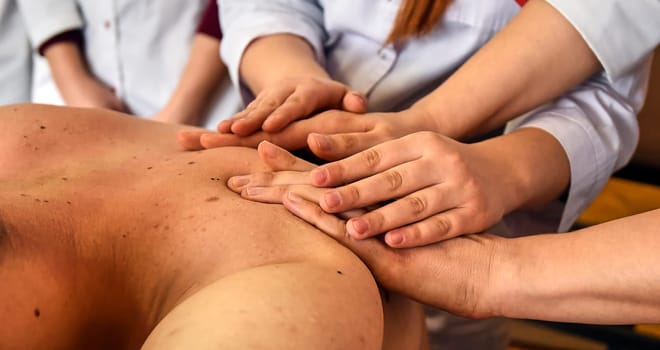 A close-up of a client's back massage. Massage lesson at the medical center.