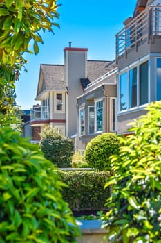 Front of houses with landscape yard on sunny day.