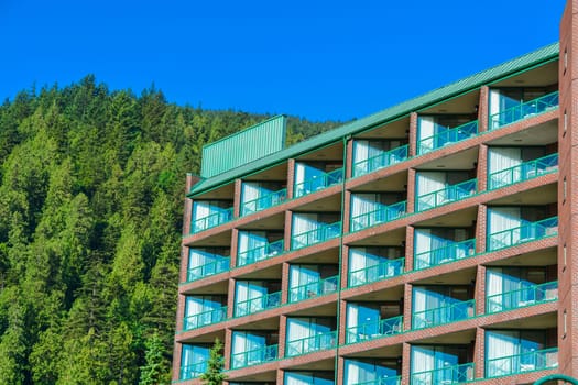 Resort building facade on mounting and blue sky background.