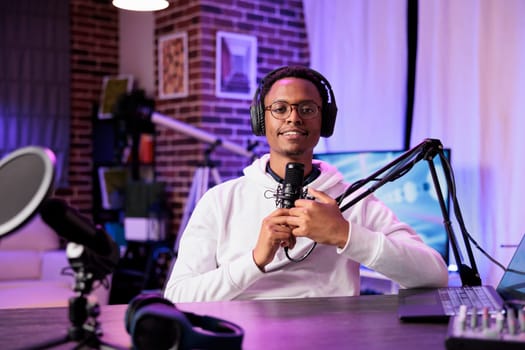 Lifestyle vlogger recording podcast episode with professional camera and sound equipment in studio. Portrait of content creator talking to audience and filming streaming service online show