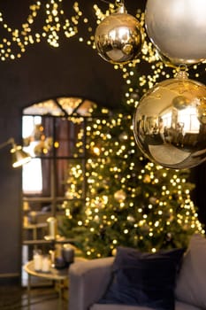 Christmas interior with a beautiful Christmas tree, sofa, light bulbs and dark background