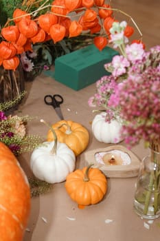 Flower arrangement in a pumpkin, autumn interior decor. Creating handmade autumn decor